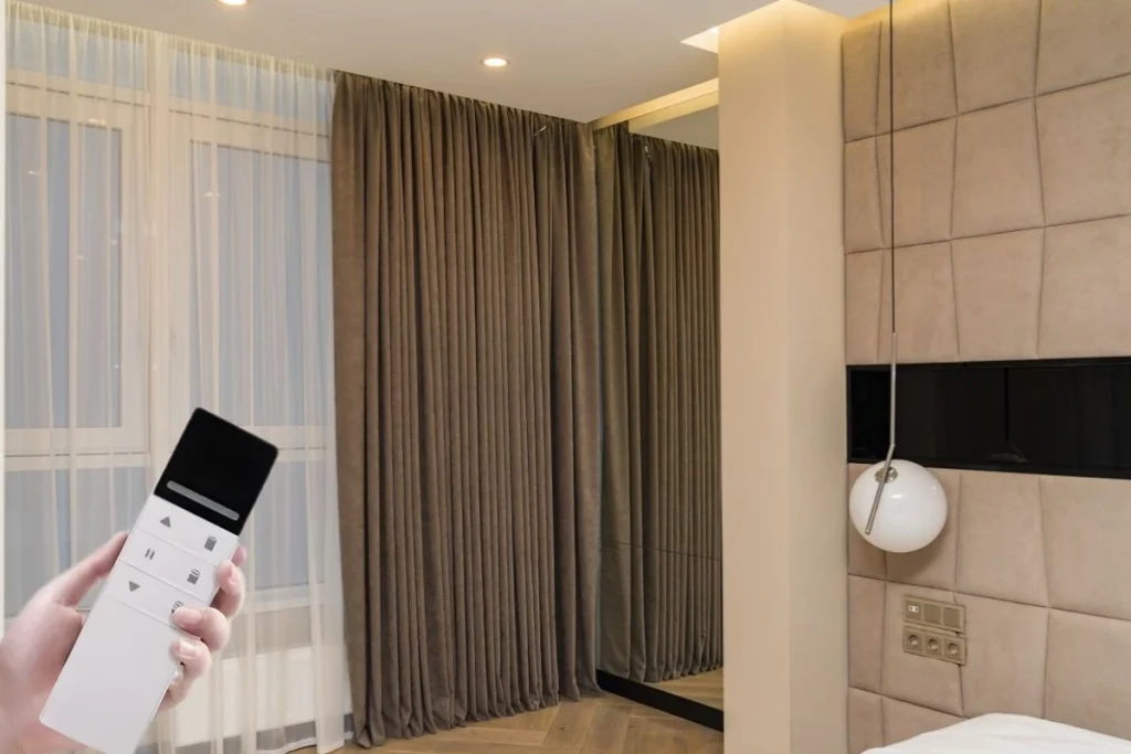 Motorized blackout curtains in a luxury Dubai bedroom with remote control.